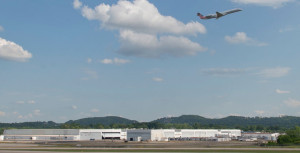 The Kaiser Aircraft facility stands in the background as a jetliner takes off at Birmingham-Shuttlesworth International Airport. (Image: Bob Farley/F8Photo.org)